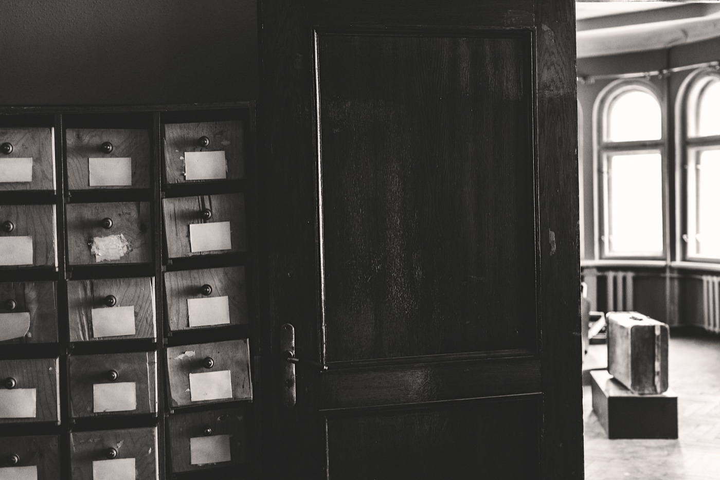 A wall of small filing cabinets, an unmarked briefcase, and an open door inside the preserved KGB Corner House at 61 Br&imacr;v&imacr;bas iela in Riga.